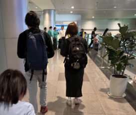Family with a young child moving through Tan Son Nhat International Airport after immigration