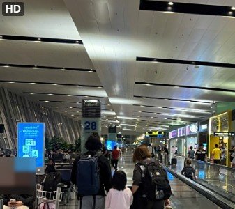 Japanese family proceeding with an airport representative toward international departure procedures at Noi Bai Airport